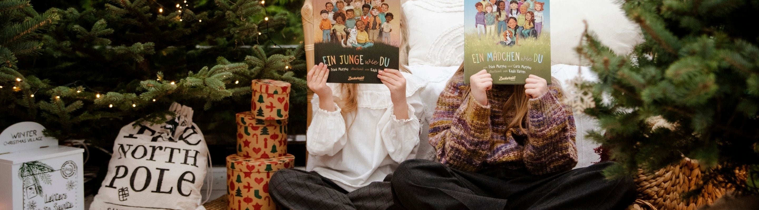 zwei Kleinkinder lesen die "Freiheit ist für alle da"-Bücher von Susann Hoffmann in weihnachtlichem Setting