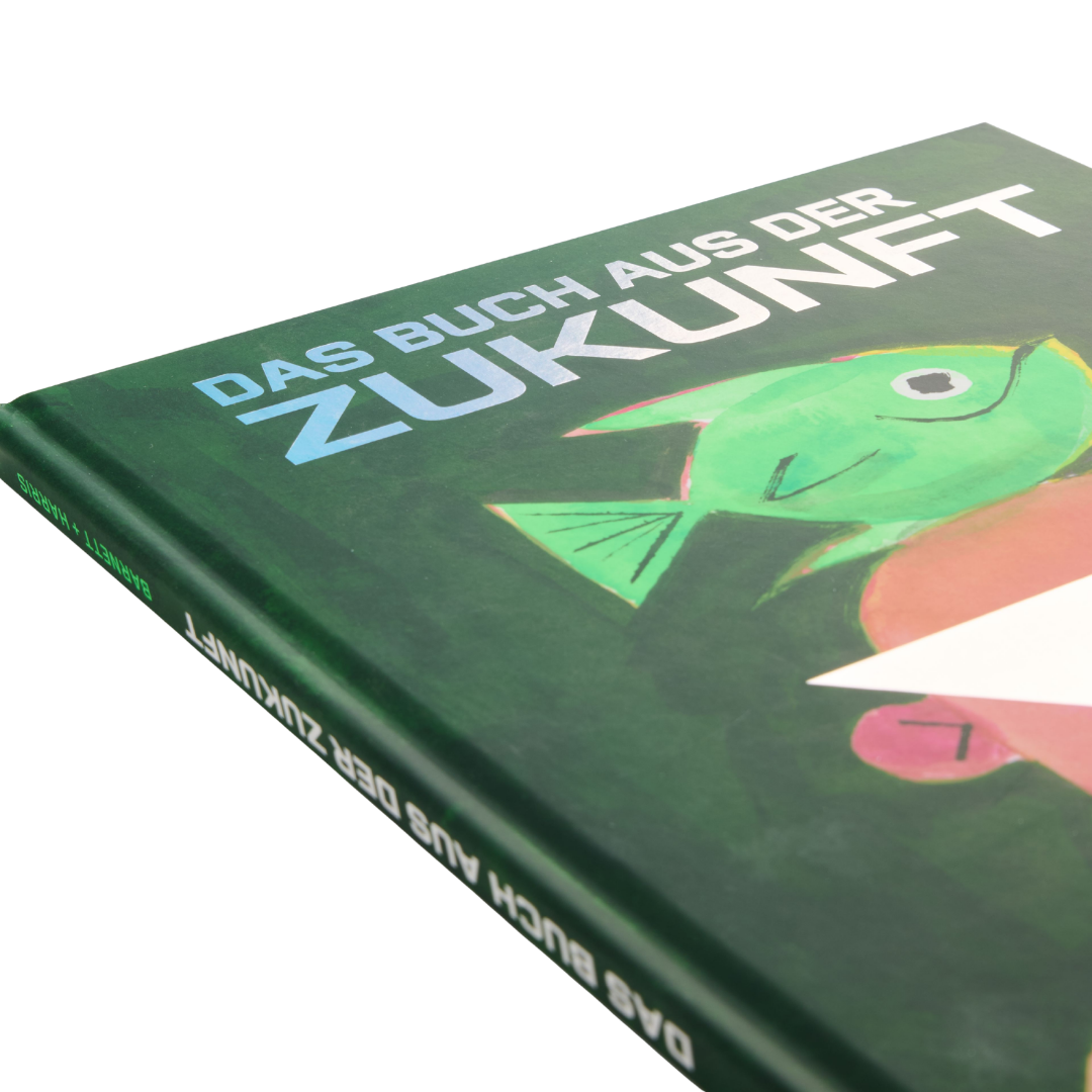 Eine Nahaufnahme eines Kinderbilderbuchs mit dem Titel „Das Buch aus der Zukunft“ vom Zuckersüß Verlag, auf dessen Einband ein grüner Fisch vor grünem Hintergrund abgebildet ist.