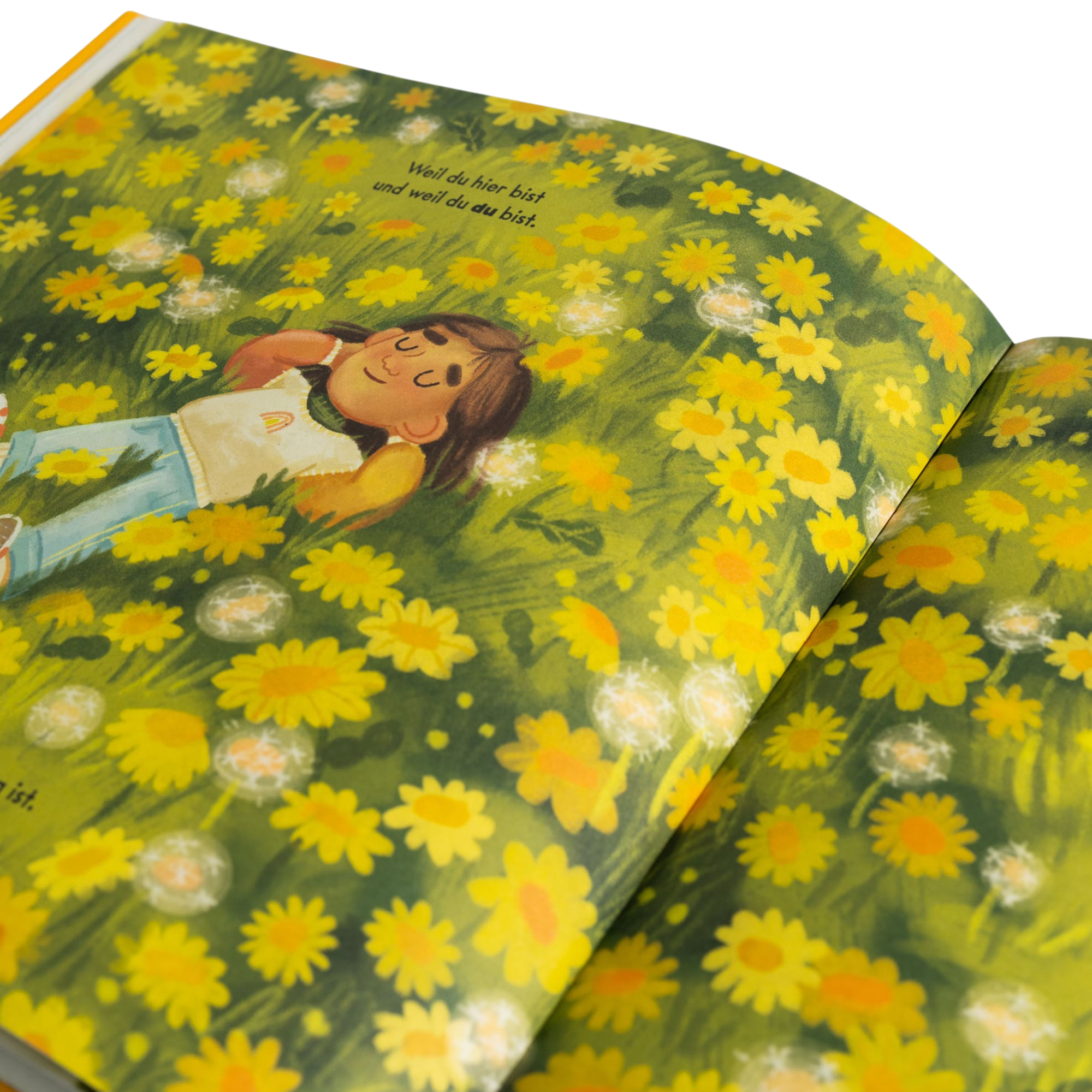 Eine Seite aus *Ich bin genau richtig* von Jessica Sanders zeigt ein Mädchen, das zwischen gelben Blumen und Löwenzahn liegt und die Augen zufrieden geschlossen hat. Der deutsche Text transportiert die Themen Selbstliebe und Glück.