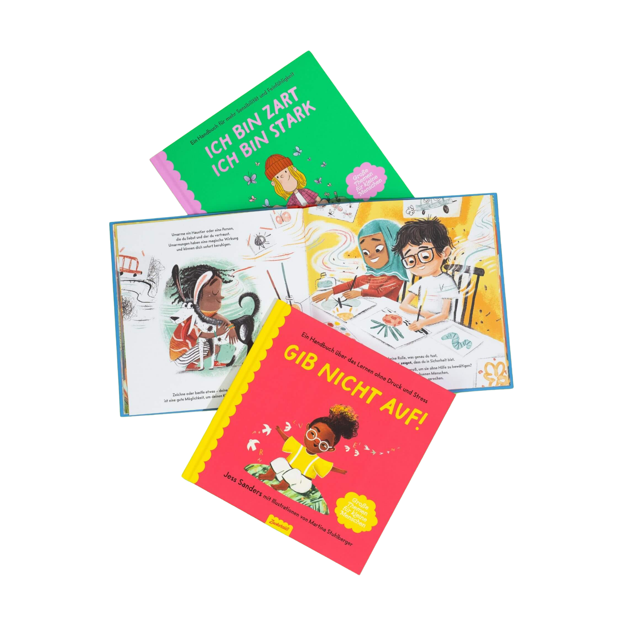 Das Mutmach-Paket vom Zuckersüß Verlag: Drei Kinderbücher, ideal zum Mutmachen. Zwei mit illustrierten Covern, eines offen mit bunten Illustrationen malender Kinder. Titel: Ich Bin Zart Ich Bin Stark und Gib Nicht Auf!.