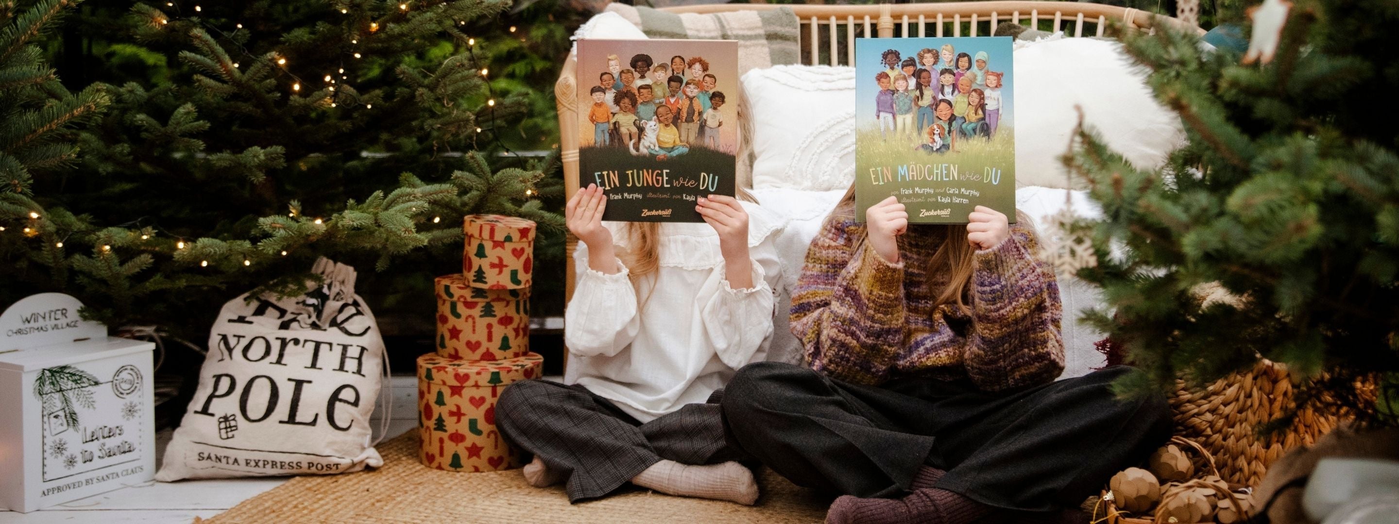 zwei Kleinkinder lesen die "Freiheit ist für alle da"-Bücher von Susann Hoffmann in weihnachtlichem Setting